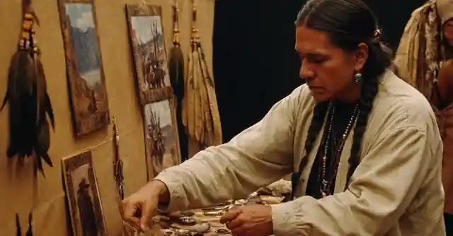 A person at an arts and crafts fair picking out beautiful Apache Tears, amidst the background of a historical Apache tribe display.