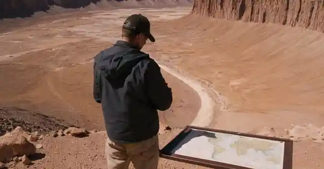 A traveler standing at the rim of Barringer Crater with a map highlighting key points.