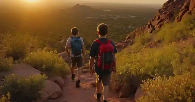 Kids hiking on Camelback Mountain with backpacks in the sunset.
