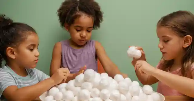 Children experiencing different textures with cotton balls at a sensory learning station.