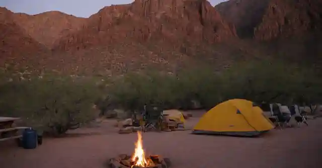 Persona experimentando en la naturaleza, acampada y montañas al fondo.**Translation:** A person camping outdoors amidst nature and mountains in the backdrop.Note that it captures the heart of what makes Arizonas KOA (Kampgrounds Of America) appealing - immersing yourself in natural landscapes, offering a unique experience combining adventure with relaxation, all under one roof or campsite accommodations where modern comfort and traditional camping essentials are accessible.