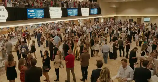 People engaging in various activities at the Principal event in Gilbert with signs showing different ticket prices and entertainment options.