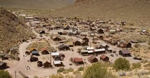 A map highlighting various trails and points of interest in the historic Goldfield Ghost Town with visitors engaging in activities.