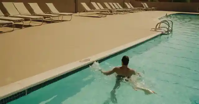 Person swimming leisurely at public pool in the Phoenix heat.