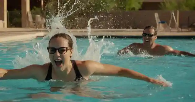 Swimming enthusiasts splashing and having fun in a lively public pool scene in Phoenix.