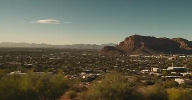 An individual with allergies in Tempe holding up an air quality alert app displaying current pollen index.