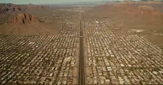 Individual weighing pros and cons on scales representing liveability factors in various aspects of life in Phoenix, Arizona.