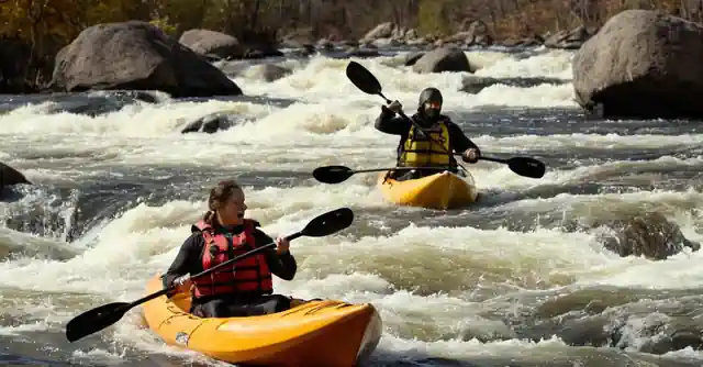 Kayak enthusiasts navigating the rapids during a Halloween season event organized by Mild2Wild.