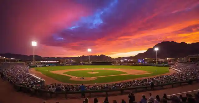 A vibrant night scene with colorful lights illuminating the sky over Salt River Fields.