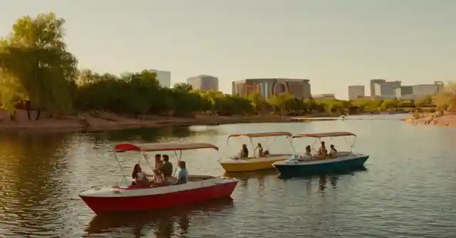 Boaters looking at various advertisements for donut boat rentals along the shores of Tempe Town Lake.